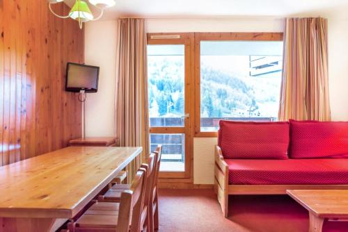 un salon avec un canapé rouge et une table dans l'établissement Quartier Crève Cœur - maeva Home - 2 Pièces 5 Personnes Confort MAE-2007, à Valmorel