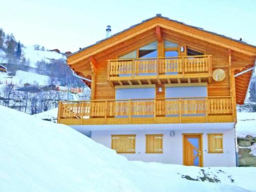 Casa de madera con balcón en la nieve en Chalet Falcons Nest, en Hérémence