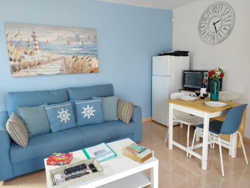 sala de estar con sofá azul y mesa en Casa Del Mar - Corralejo Playa, en Corralejo