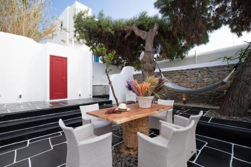 a patio with a table and chairs and a tree at Spitarona Town House - Largest VIlla in the Center in Mýkonos City