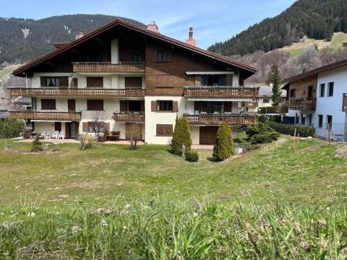 a large building with a grass field in front of it at 3 12 Zimmer Wohnung "Haus Fless" in Klosters