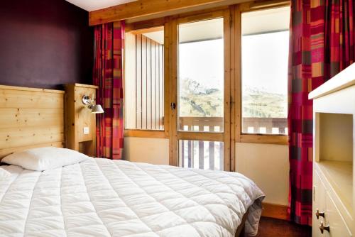 une chambre avec un lit et une grande fenêtre dans l'établissement Résidence Les Néreïdes - maeva Home - 3 Pièces 7 Personnes Sélection MAE-2010, à La Plagne Tarentaise