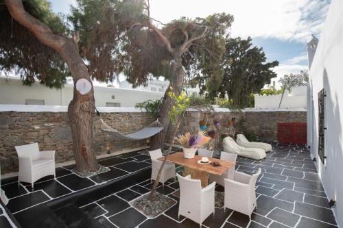 a patio with a tree and a table and chairs at Spitarona Town House - Largest VIlla in the Center in Mýkonos City