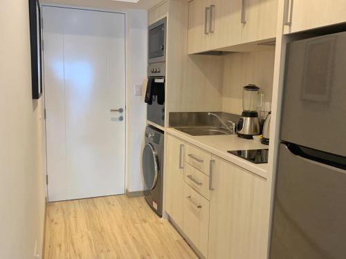 a small kitchen with a sink and a refrigerator at Primera Parada By Wynwood House in Lima