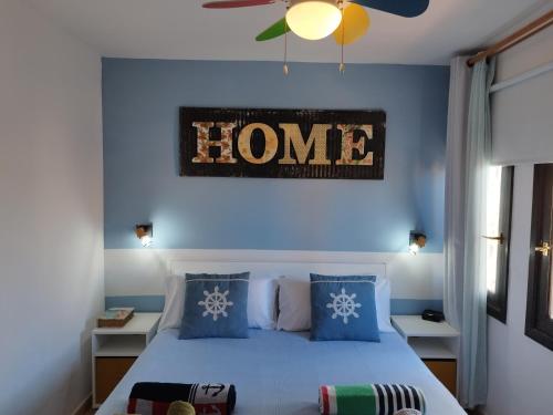 Un dormitorio con paredes azules y una cama con un letrero que lee a casa en Casa Del Mar - Corralejo Playa, en Corralejo