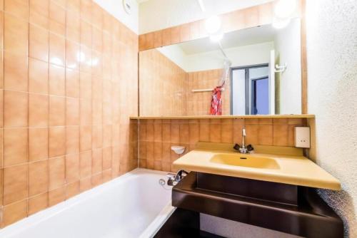 uma casa de banho com um lavatório e uma banheira em L'Aiguille - maeva Home - 2 Pièces 5 Personnes Confort 39 em Chamonix-Mont-Blanc
