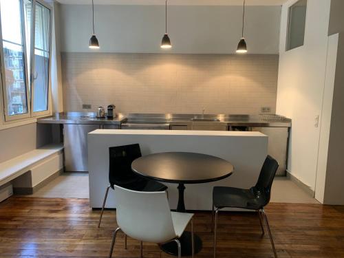 une cuisine avec une table, des chaises et un comptoir dans l'établissement loft Montmartre au pieds des vignes, à Paris