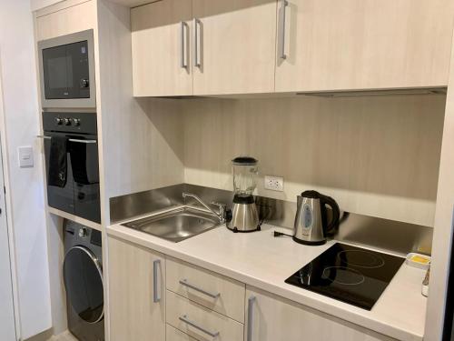 a small kitchen with a sink and a stove at Primera Parada By Wynwood House in Lima