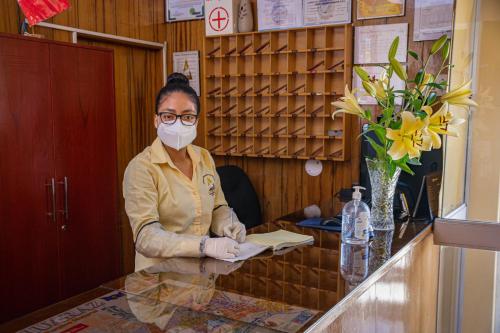 a woman wearing a face mask at a counter at Hotel Independencia in Huaraz