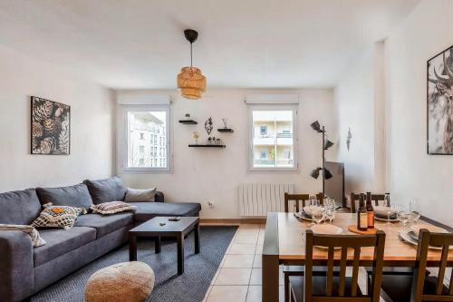 a living room with a couch and a table at Cosy appartement - Parking Privé Gratuit in Chambéry