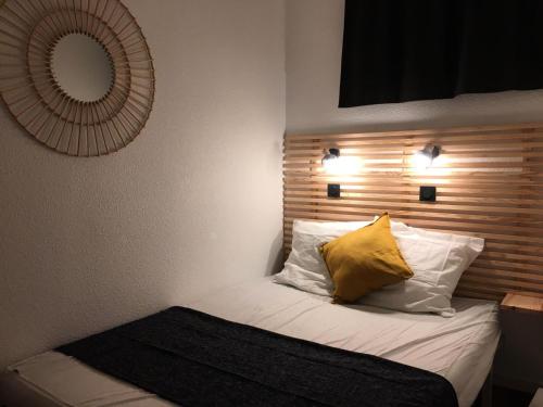 - un lit avec un oreiller jaune et un miroir dans l'établissement Résidence Le Cédrat - maeva Home - Appartement 2 pièces 5 personnes au pied des pistes - Prestige - Super Home MAE-3437, à Avoriaz