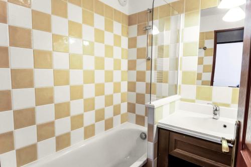 une salle de bain avec une baignoire et un lavabo dans l'établissement Résidence L'Albane - maeva Home - 2 Pièces 5 Personnes Sélection MAE-3495, à Vars