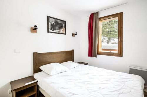 une chambre avec un grand lit blanc avec une fenêtre dans l'établissement Résidence L'Albane - maeva Home - 2 Pièces 5 Personnes Sélection MAE-3495, à Vars