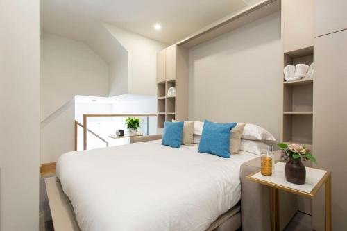 een slaapkamer met een groot wit bed met blauwe kussens bij Exquisite Studio - Heart of Reading Centre in Reading