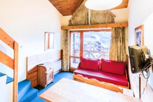 - un salon avec un canapé rouge et une fenêtre dans l'établissement Quartier Crève Cœur - maeva Home - 2 Pièces 6 Personnes Confort MAE-3620, à Valmorel