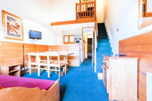 une salle à manger avec une table et des chaises et un escalier dans l'établissement Quartier Crève Cœur - maeva Home - 2 Pièces 6 Personnes Confort MAE-3620, à Valmorel