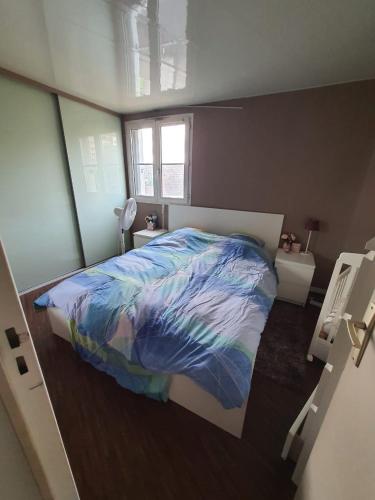 une chambre avec un lit avec une couette colorée dans l'établissement Appartement 3 pièces à Fresnes, à Fresnes
