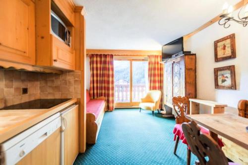 une cuisine et un salon avec une table et des chaises dans l'établissement Résidence Les Sentiers du Tueda - maeva Home - 2 Pièces 4 Personnes Sélection MAE-3511, à Les Allues