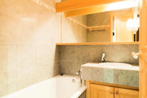 une salle de bain avec une baignoire et un lavabo dans l'établissement Résidence Les Sentiers du Tueda - maeva Home - 2 Pièces 4 Personnes Sélection MAE-3511, à Les Allues