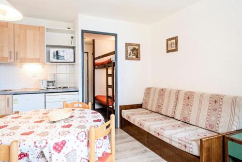 Cette chambre dispose d'une table, d'un canapé et d'une cuisine. dans l'établissement Résidence Les Alpages - maeva Home - Studio 4 Personnes Confort MAE-3632, à Morzine