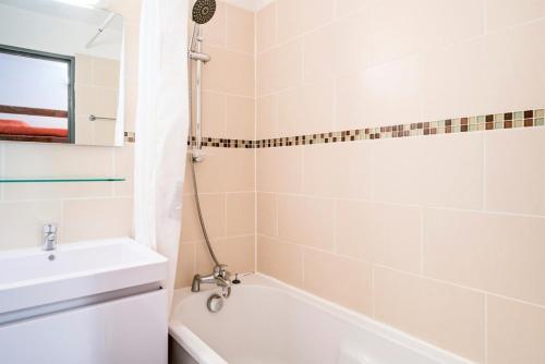 une salle de bain avec une baignoire blanche et un lavabo dans l'établissement Résidence Les Alpages - maeva Home - Studio 4 Personnes Confort MAE-3632, à Morzine