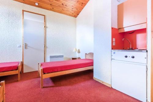 um pequeno quarto com uma cama e uma cozinha em Quartier Crève Cœur - maeva Home - Duplex 3 Pièces 8 Personnes Confort 03 em Valmorel
