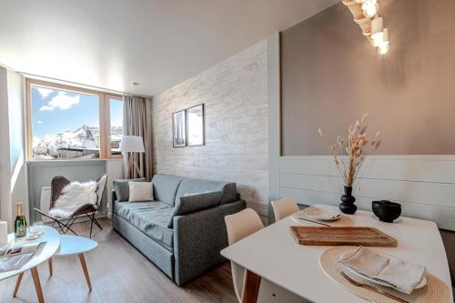un salon avec un canapé et une table dans l'établissement Résidence Les Fontaines Blanches - maeva Home - 2 Pièces 4 Personnes Sélection MAE-3634, à Morzine