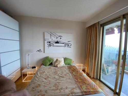 - une chambre avec un lit et une grande fenêtre dans l'établissement 2-Room 60 m², Panoramic view, 2 balconies, 50m Pool, à Cagnes-sur-Mer