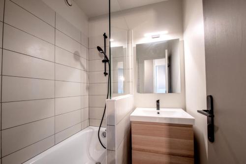 une salle de bain blanche avec un lavabo et une douche dans l'établissement Résidence Les Fontaines Blanches - maeva Home - 2 Pièces 4 Personnes Sélection MAE-3634, à Morzine