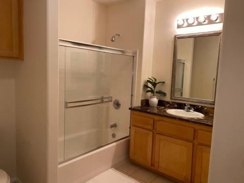 y baño con ducha, lavabo y espejo. en Orsini Luxury Retreat: 2BR/2BA en Los Ángeles