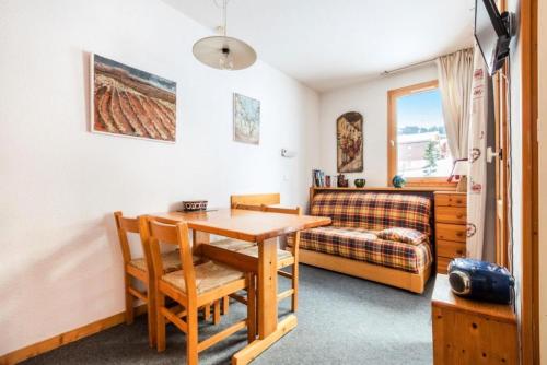 Cette petite chambre comprend une table et un canapé. dans l'établissement Quartier La Forêt - maeva Home - Studio 4 Personnes Confort MAE-3775, à Valmorel