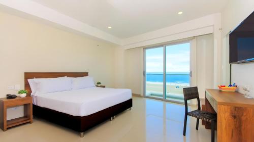 a bedroom with a bed and a view of the ocean at Hotel Summer Frente Al Mar in Cartagena de Indias