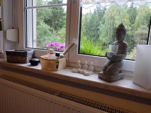 巴特埃爾斯特的住宿－Ferienhaus am Wald mit Sauna，窗台,窗前有雕像