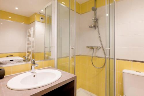 uma casa de banho com um lavatório e um chuveiro em Résidence Les Sentiers du Tueda - maeva Home - 3 Pièces 8 Personnes Prestig 84 em Les Allues