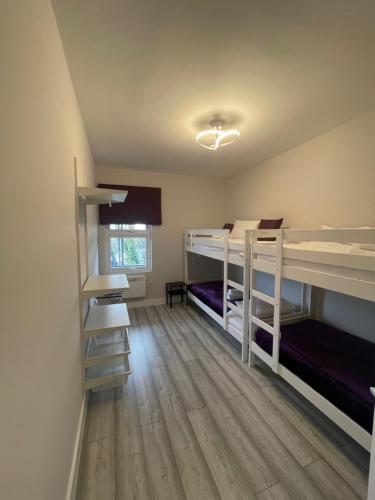 a room with two bunk beds and a wooden floor at Chamberlayne Inn in London