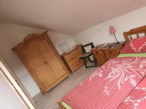 a bedroom with a bed and a wooden cabinet at Im Herzen des Elbsandsteingebirges in Königstein an der Elbe