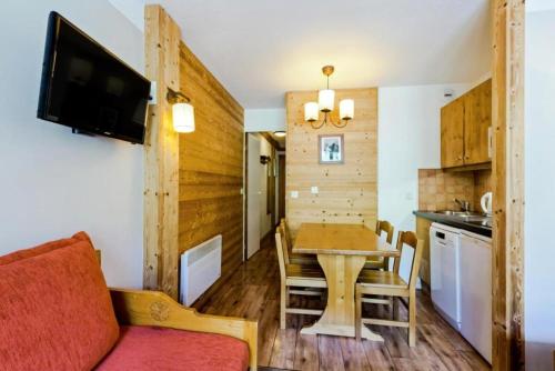 - une cuisine et une salle à manger avec une table et un canapé dans l'établissement Résidence Les Sentiers du Tueda - maeva Home - 2 Pièces 4 Personnes Sélection MAE-4189, à Les Allues