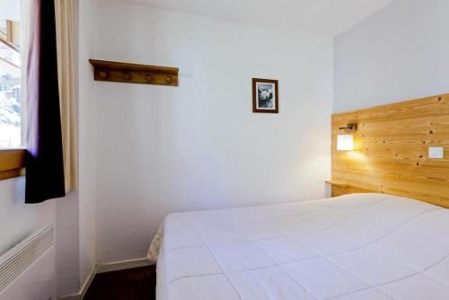 une chambre avec un lit blanc et une fenêtre dans l'établissement Résidence Les Sentiers du Tueda - maeva Home - 2 Pièces 4 Personnes Sélection MAE-4189, à Les Allues