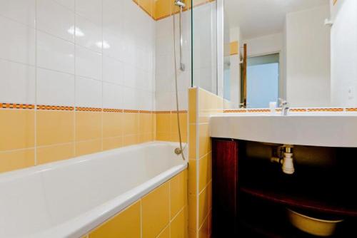 une salle de bain avec un lavabo et une baignoire dans l'établissement Résidence Les Sentiers du Tueda - maeva Home - 2 Pièces 4 Personnes Sélection MAE-4189, à Les Allues