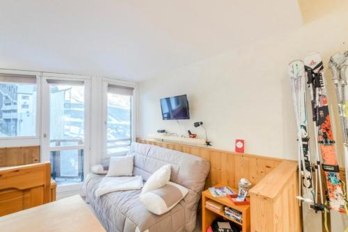 - un salon avec un canapé et des skis sur le mur dans l'établissement Résidence quartier Hauts-Forts - maeva Home - Studio 2 Personnes Confort - La Pointe de Vorlaz MAE-4215, à Morzine
