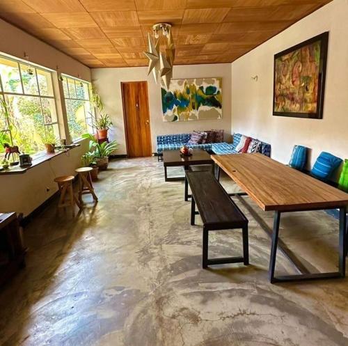 ein Wohnzimmer mit einem großen Holztisch und Stühlen in der Unterkunft Hotel Muchá in Quetzaltenango