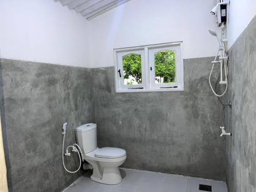 a bathroom with a toilet and a window at ORENDA ECO LODGE & SPA in Galle