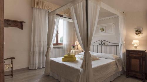 1 dormitorio con cama con dosel y ventana en La Sassolina, en Montaione