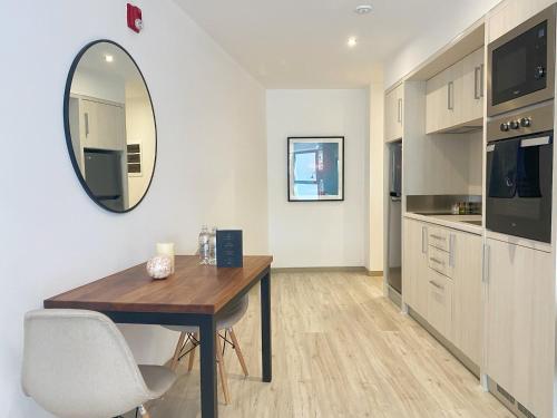 a kitchen with a wooden table and a mirror at Primera Parada By Wynwood House in Lima