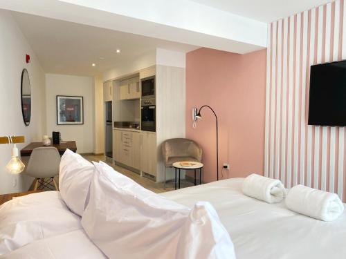 a bedroom with a white bed and a kitchen at Primera Parada By Wynwood House in Lima