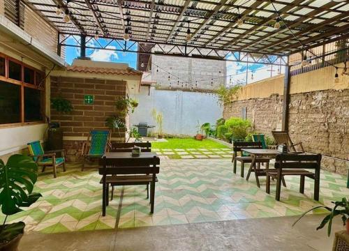 an outdoor patio with tables and chairs and a building at Hotel Muchá in Quetzaltenango