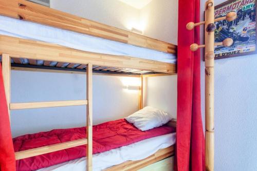 a bedroom with two bunk beds with red curtains at Studio 4 pers pied des pistes - maeva Home 72251 in L'Alpe-d'Huez