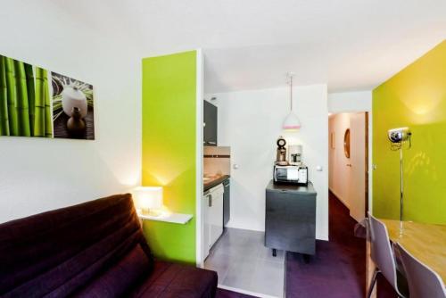 un salon avec un canapé et une cuisine dans l'établissement Résidence Les Sentiers du Tueda - maeva Home - 2 Pièces 4 Personnes Confort MAE-5746, à Les Allues