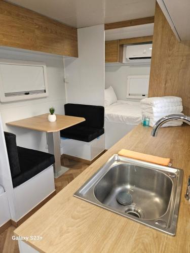 a kitchen with a sink and a caravan with a bed at יהליס קראונים נגררים השכרת קראוונים in Baraq