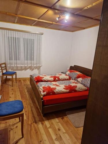 sypialnia z łóżkiem i krzesłem w pokoju w obiekcie Appartamento di vacanza w mieście Poschiavo